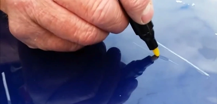 car scratch pencil in use in blue car